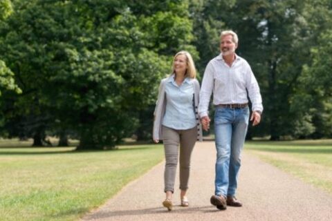 Healthy couple walking by holding their hands, AZ