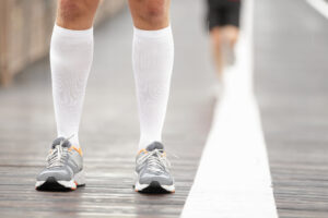 A man in white socks and running shoes, promoting exercise for better circulation in Phoenix, AZ
