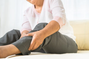 leg pain of senior woman at home