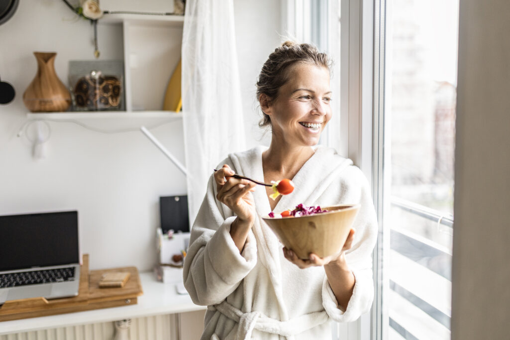 Woman in a bathrobe enjoying a healthy breakfast, promoting good vein health in Phoenix, AZ