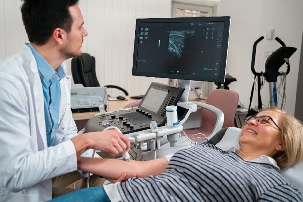 A doctor performing a vascular ultrasound on a woman’s arm by Arizona Vein & Laser Institute