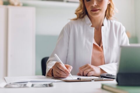 Doctor writing notes during consultation about vein treatment options in Phoenix, AZ, & surrounding areas