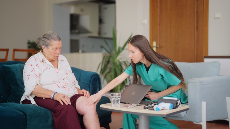 Healthcare provider examining elderly woman’s leg for vein or circulation issues in Phoenix, AZ, & surrounding areas